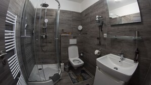 A modern bathroom with a glass-enclosed shower, a toilet, and a sink. - VALLA penzión&reštaurácia (Malacky)