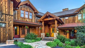 A large, rustic wooden house with a stone pathway leading to the entrance, surrounded by lush greenery. - Gorgeous Private Home with Breathtaking Views of Red and Buffalo Mountain! (Silverthorne)