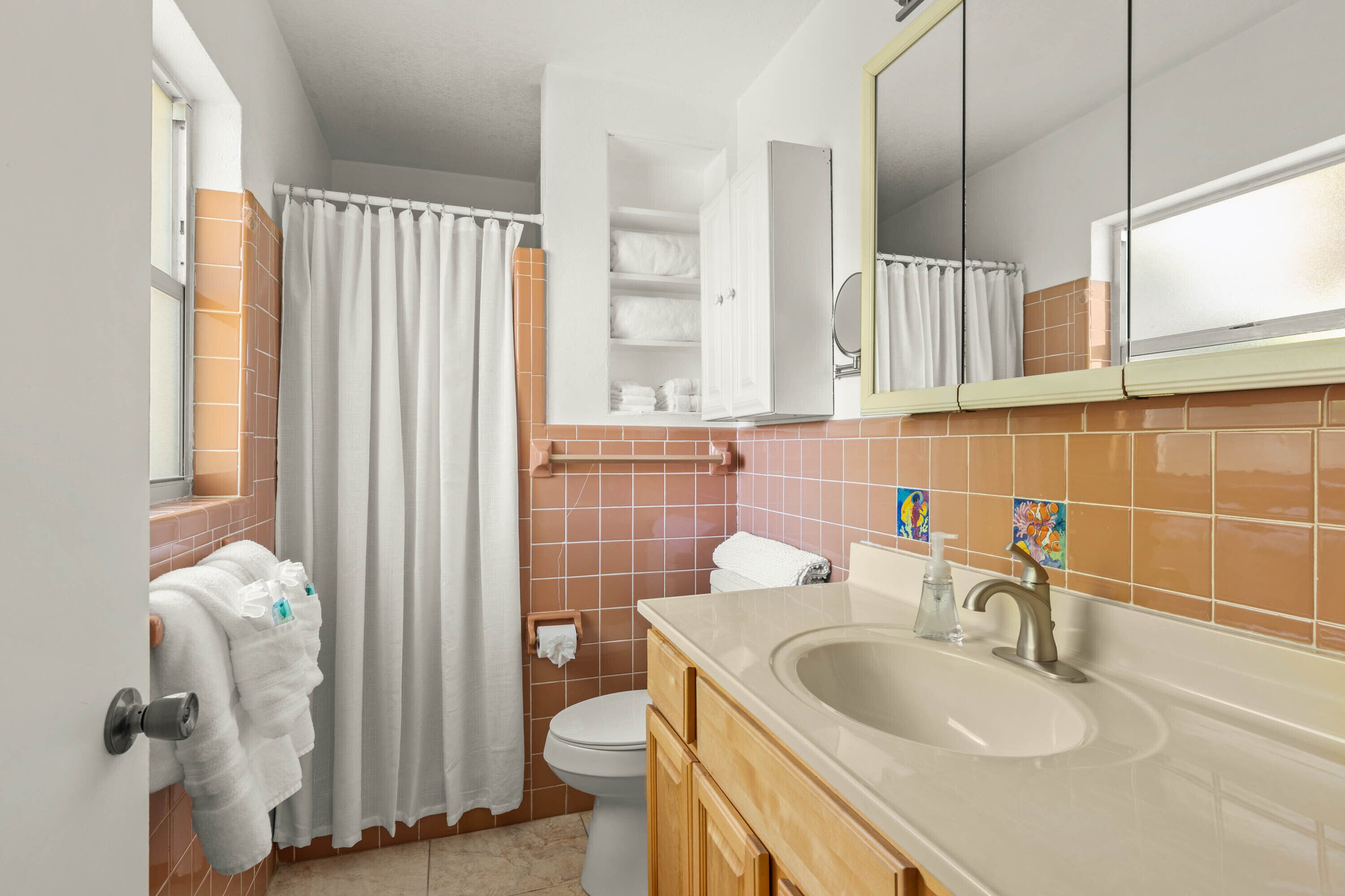A bathroom with a sink, mirror, toilet, and towel rack.