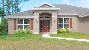 A two-story house with a front entrance, a covered porch, and a small front yard. - Palm Bay Retreat: Pool, Amenities & Free Parking
 (Palm Bay)