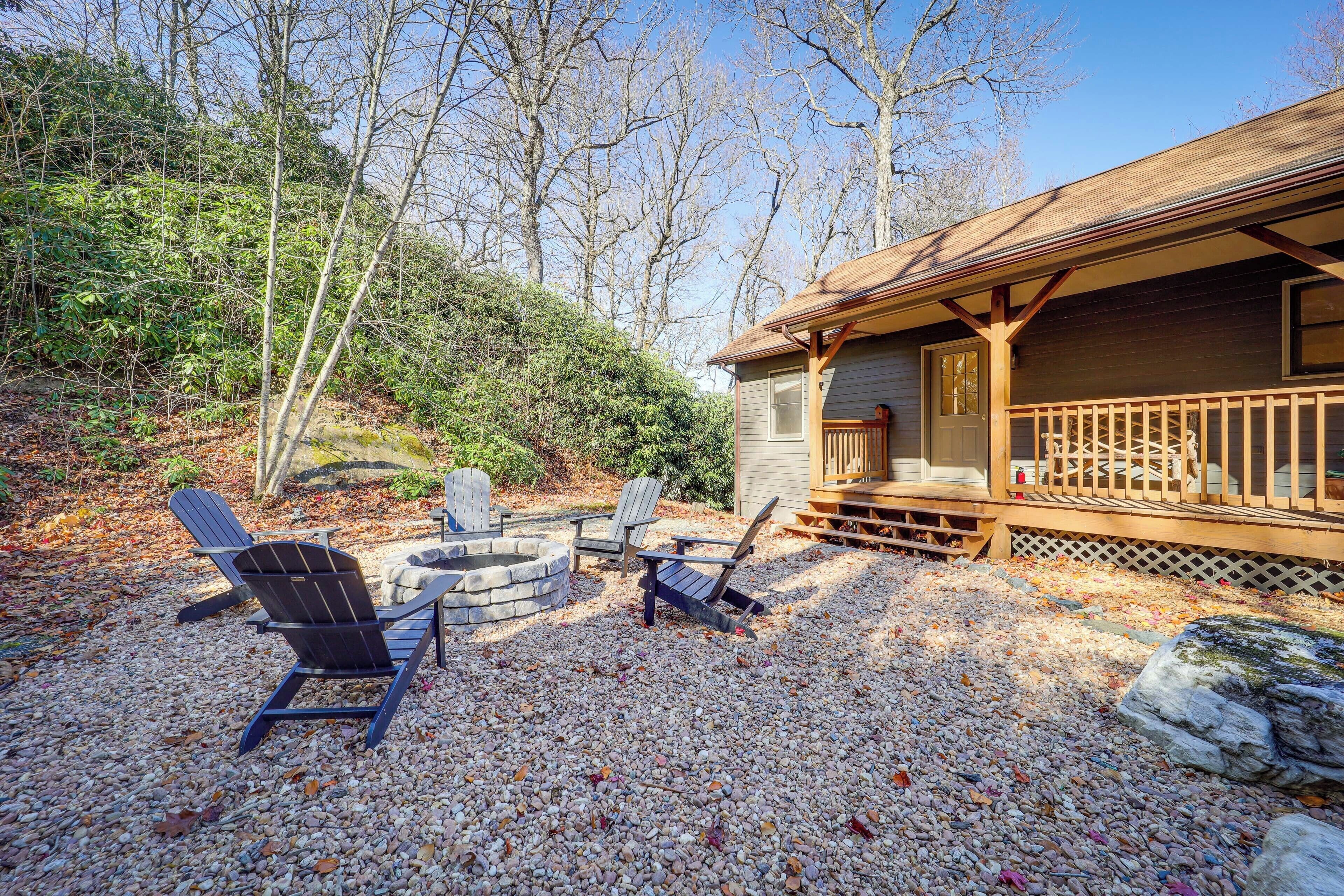 A cabin with a deck, outdoor seating, and a fire pit.