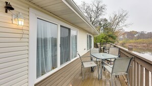 A covered deck with a table and chairs, overlooking a body of water. - Salem Vacation Home w/ Dock: Steps to Paddock Lake (Salem)