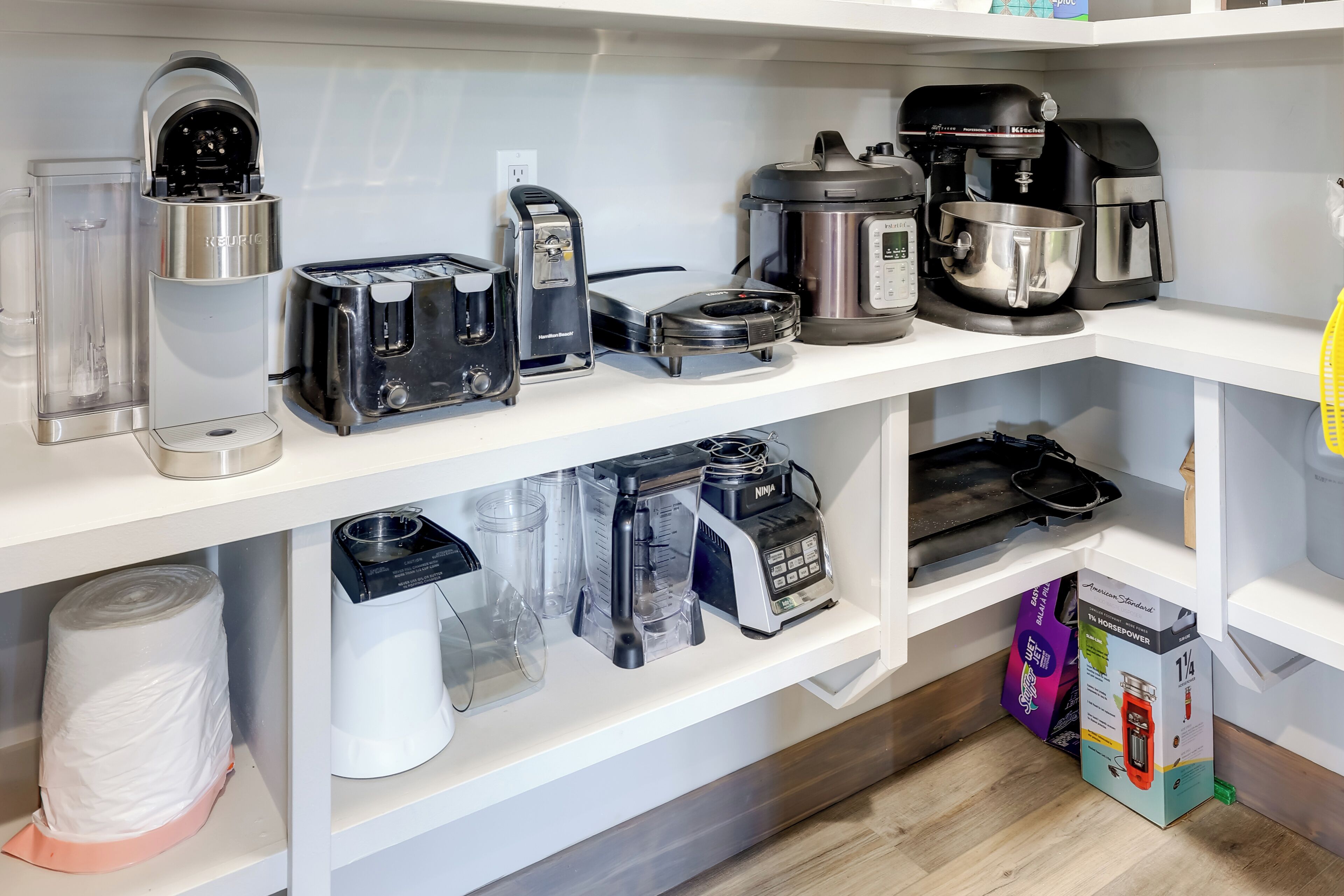 Une cuisine équipée de divers appareils, notamment une machine à café, un grille-pain, un mixeur et un robot culinaire.