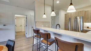 A modern kitchen with a white countertop, stainless steel appliances, and pendant lighting. - Suncadia Resort Condo: Balcony & Golf Course Views (Cle Elum)