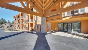 A modern building with a covered outdoor area, large windows, and a stone pillar. - Suncadia Resort Condo: Balcony & Golf Course Views (Cle Elum)