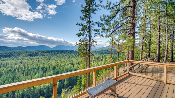 A wooden deck with a bench overlooking a forested valley and mountains. - Suncadia Resort Condo: Balcony & Golf Course Views (Cle Elum)