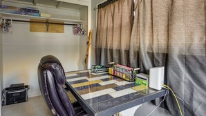 A compact room with a glass-top table, a leather chair, a guitar, and a shelf with board games. - Charming Ogden Vacation Rental: 2 Mi to Downtown (Ogden)