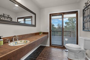 Enjoy a refreshing bathroom with a spacious vanity, mirror, and sliding door leading to an outdoor deck.
