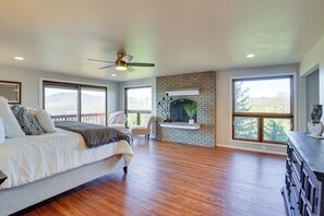 Relax by the brick fireplace in this spacious room with a large bed and natural light pouring in from two large windows.