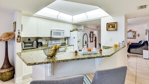 A modern kitchen with white cabinets, a granite countertop, and a central island.