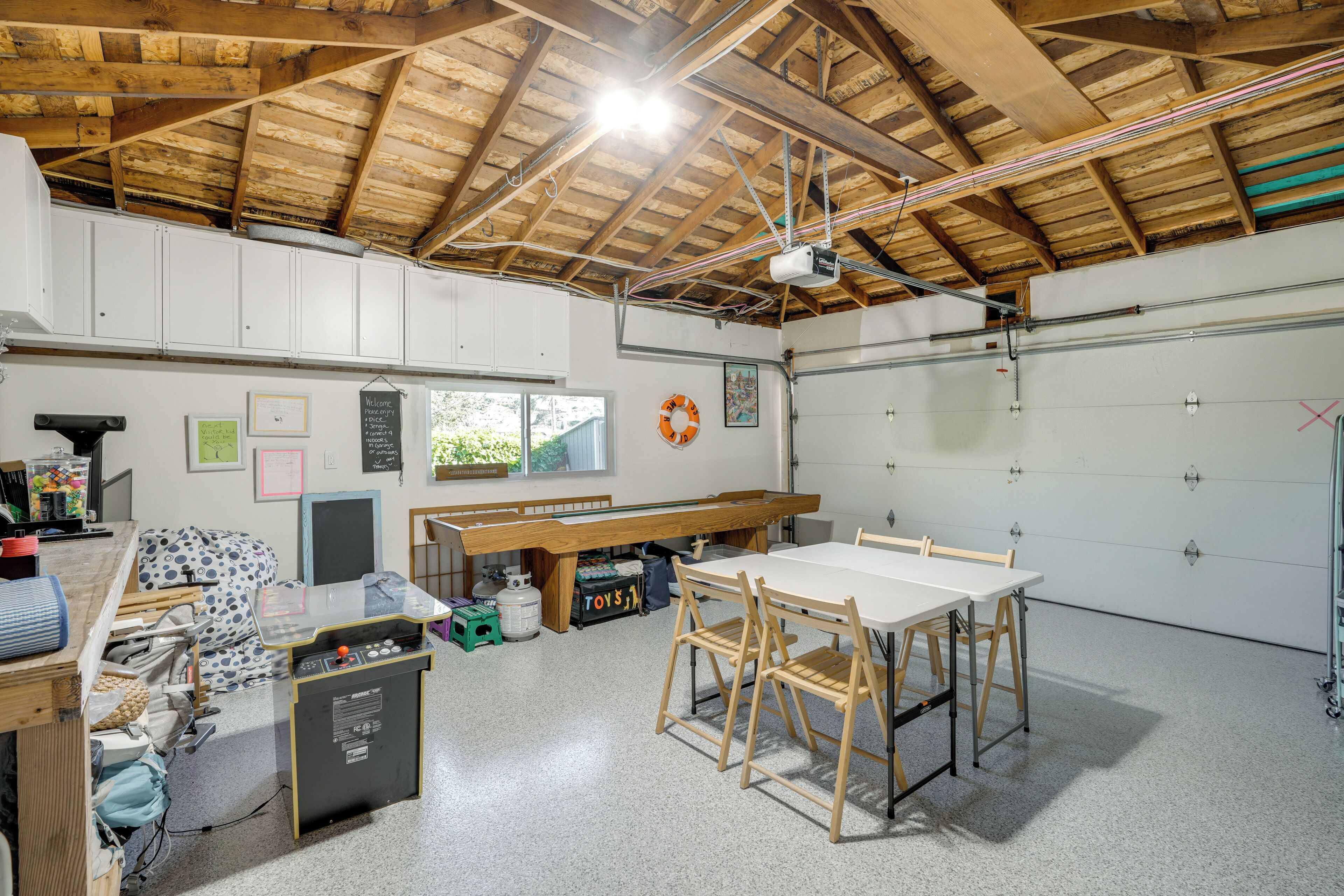 Un atelier équipé d’un établi, de tables, de chaises, ainsi que de divers outils et équipements.