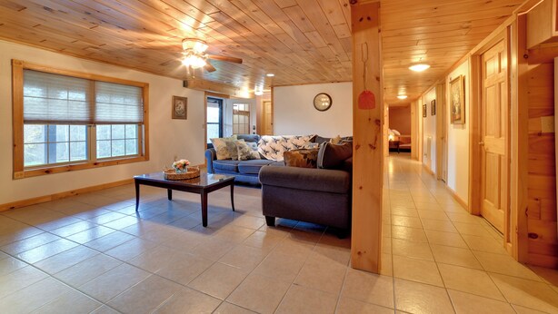 A spacious living room with a sofa, a coffee table, and a wooden ceiling.