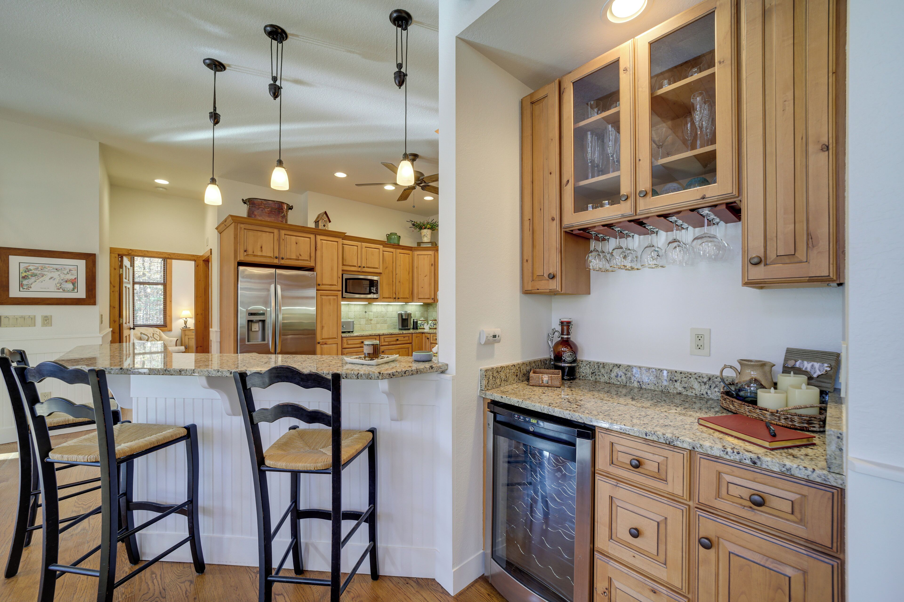 A kitchen with wooden cabinets, a stainless steel refrigerator, a microwave, and a dishwasher.