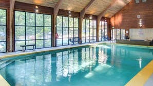 A large indoor swimming pool with clear blue water, wooden beams on the ceiling, and large windows offering views of the outdoors. - 5 Mi to Sapphire Valley Skiing: Serene Family Home (Sapphire)
