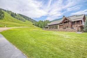 A lodge with a stone facade, large windows, and a prominent staircase leading to the entrance. - Ski-In & Ski-Out Alpine Enchantment | Beaver Creek (Beaver Creek)