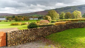 A stone wall with a wooden gate, a grassy field, and a lake in the background. - Townend Farmhouse - Watermillock, Ullswater (Watermillock)