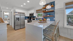 A modern kitchen with white cabinetry, stainless steel appliances, and a central island. - 🐟30A Close to Beach-Snowbird Friendly-Beachside Villas-A Sandy Carol (Santa Rosa Beach)