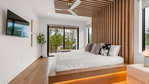 A modern bedroom with a large bed, wooden panel ceiling, and a view of the outdoors. - Brand New home with Incredible Rooftop Deck and Pool! - Just Breathe (Anna Maria)