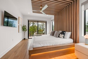 Un dormitorio moderno con una cama grande, techo de paneles de madera y vistas al exterior.