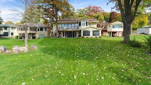 A two-story house with a large front lawn and a garage. - The Lake House on Powers |Grassy Frontage |Lakeside Deck |Rec Room w/Pool Table & Bar |Fire Pit (Genoa City)