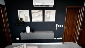 A modern living room with a sofa, a coffee table, and artwork on the wall. - Central & Spacious Penthouse w/ 1BR + City View (L-Imsida)