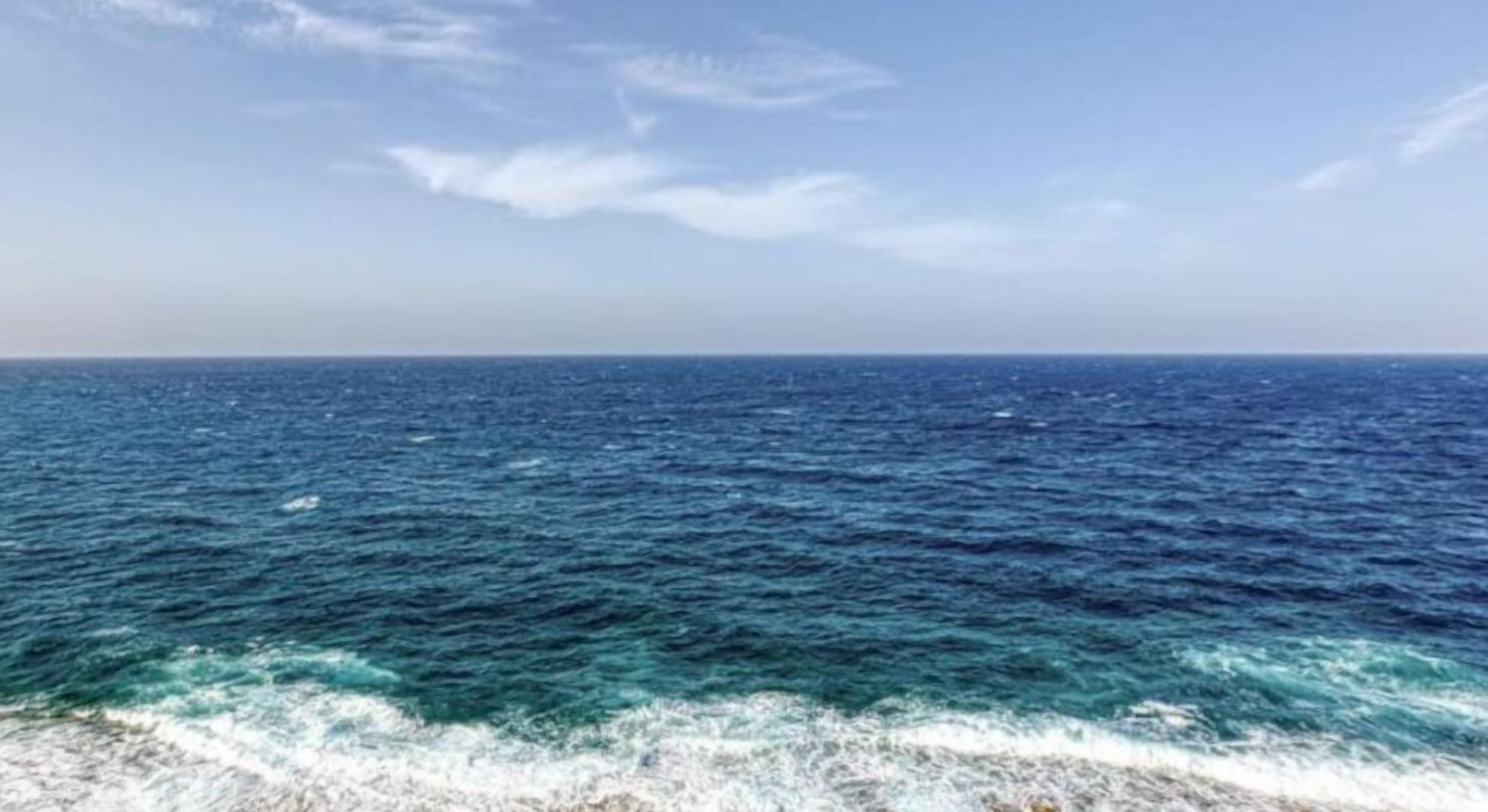 A view of the ocean with waves crashing onto the shore.