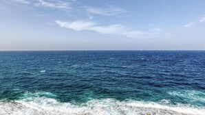A view of the ocean with waves crashing onto the shore.