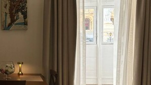 Una habitación con cama, una mesa de comedor con sillas, una lámpara y un cuadro en la pared.
