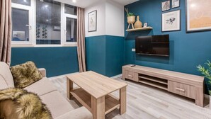 Un salon avec un canapé, une table basse, un téléviseur et un meuble pour téléviseur.
