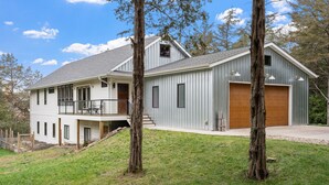 Ein zweigeschossiges Haus mit Balkon, Garage und einer Holzterrasse.
