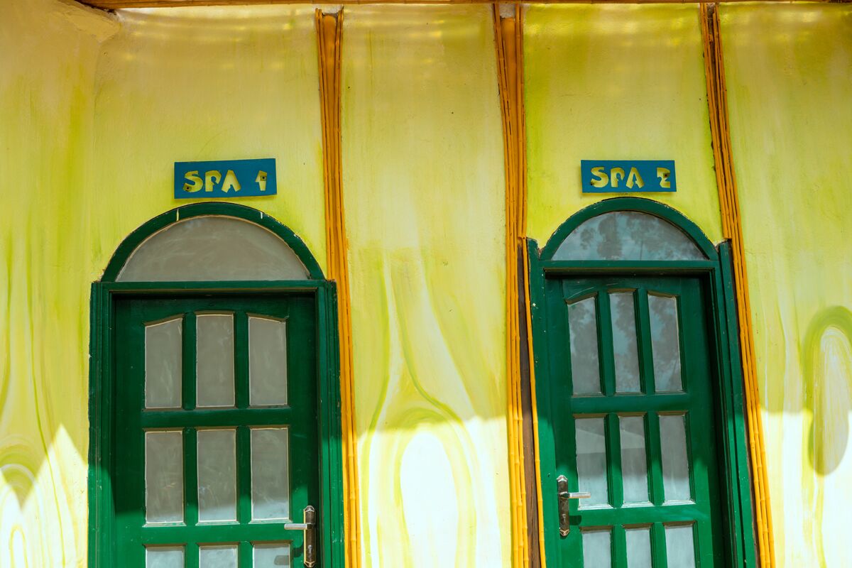 Dos puertas verdes con letreros que indican un establecimiento de spa.