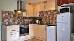 A compact kitchen with a Bosch oven, a microwave, and a dishwasher. - Little Dunley - Virginia Cottage (Bovey Tracey)