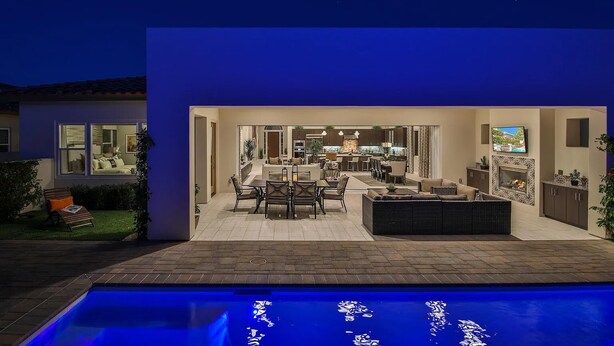 Une maison moderne dotée d’une piscine, d’un coin repas et d’une cuisine.