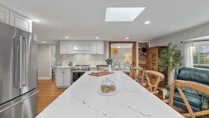 A modern kitchen with white cabinets, a marble countertop, and a built-in oven. - Your home away from home in downtown, historic Farmington! (Farmington)