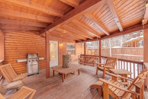 A wooden deck with a grill, wooden chairs, and a table. - In Town-Red River3Bed3Bath, In Town of Red River 3Bed 3Bath (Red River)