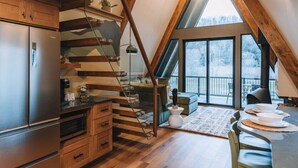 Une cuisine moderne dotée d’un réfrigérateur en acier inoxydable, de meubles en bois et d’une cuisinière encastrée.