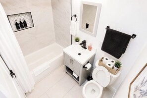 Ein modernes Badezimmer mit Badewanne, Toilette und Waschtisch.