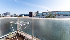 A rooftop terrace with a metal drying rack and a view of the cityscape.