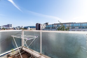 A rooftop terrace with a metal drying rack and a view of the cityscape.