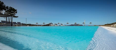 Piscine extérieure, parasols de plage, chaises longues