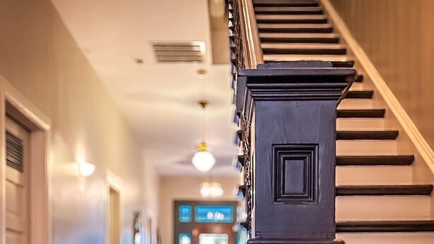 A staircase with a dark wooden handrail leading to a landing.