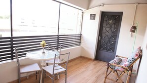 A balcony with a table, chairs, and a decorative chair. - Acqua Flats Residence  (Jaguariuna)