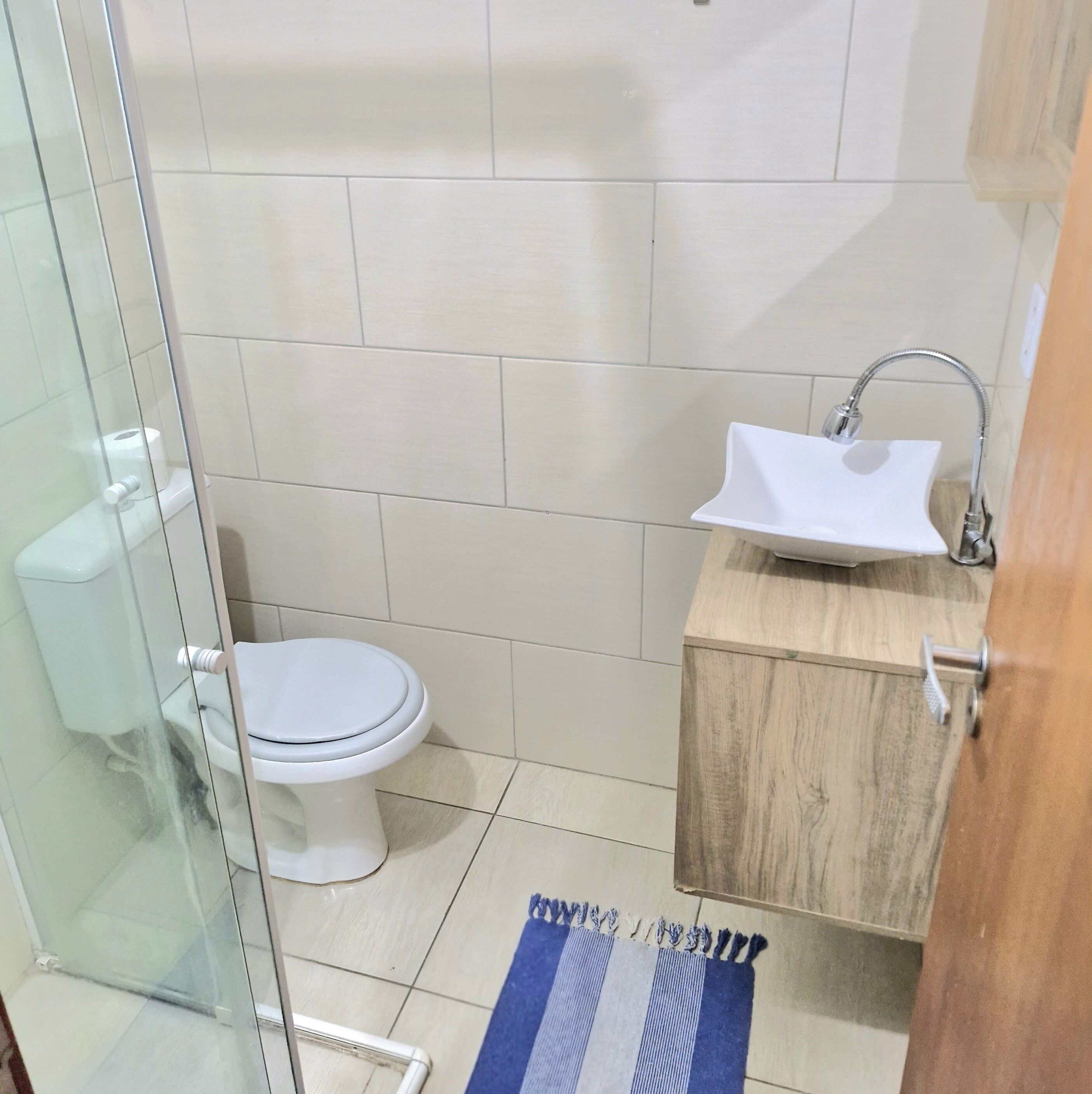 Un bagno piccolo con il water, un lavandino e una cabina doccia in vetro.