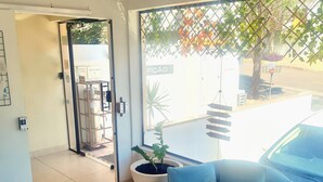 A modern interior with a blue sofa, a potted plant, and a tiled floor. - Acqua Flats Residence  (Jaguariuna)