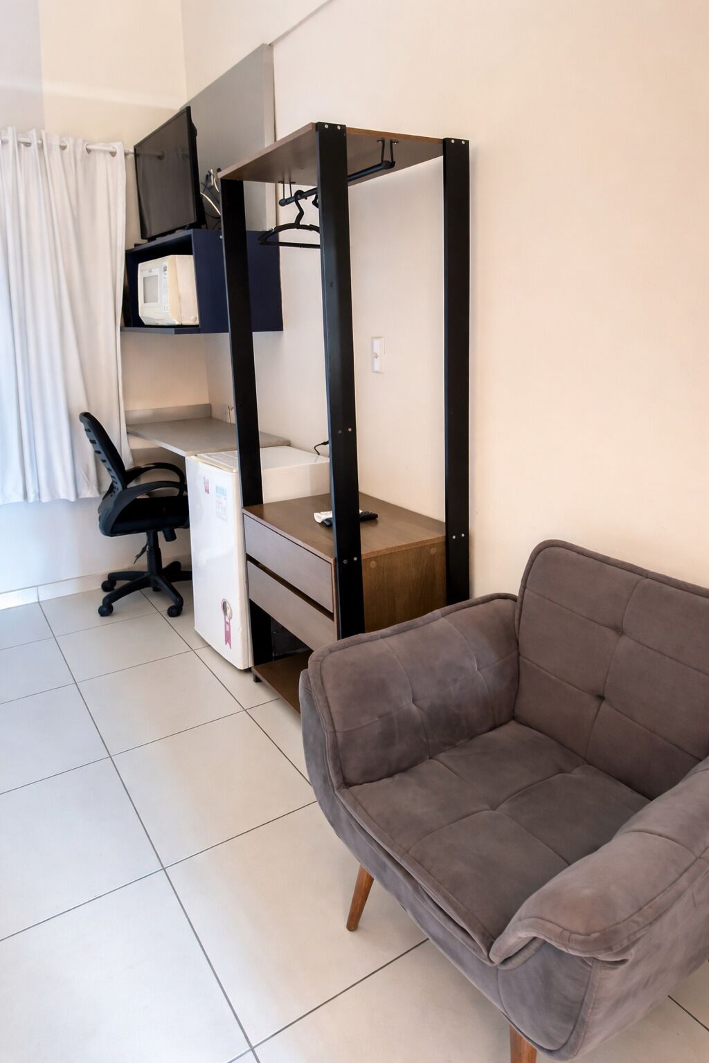Una habitación con una cama nido, un escritorio, una silla y un sofá.