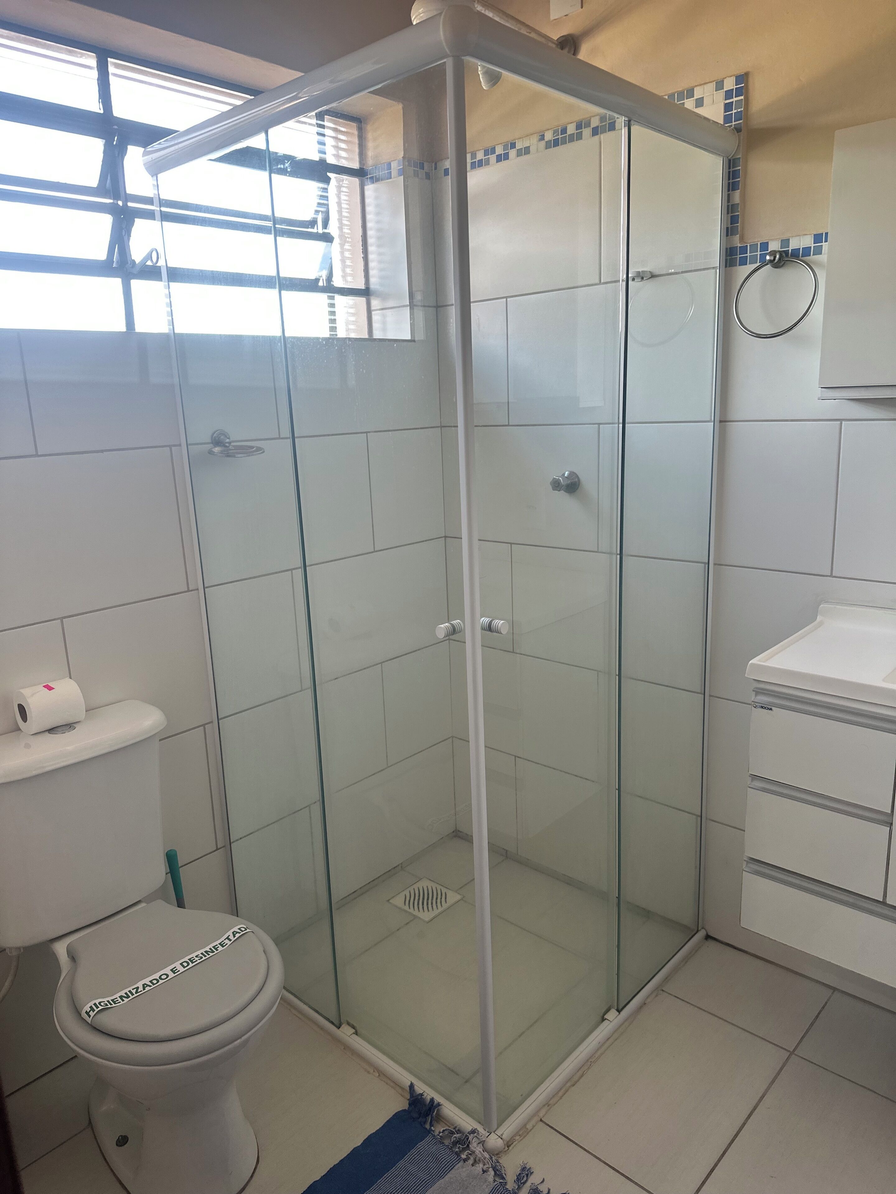 Un baño con ducha de vidrio, inodoro y lavamanos.