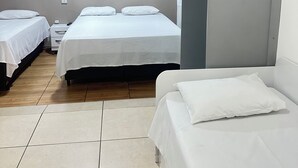 A hotel room with two single beds, a small bedside table, a wardrobe, and a tiled floor. - Acqua Flats Residence  (Jaguariuna)
