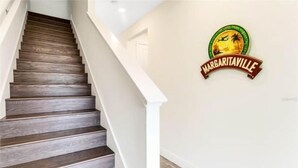 A staircase with dark wooden steps and white walls. - Margaritaville 3 bedroom home 3201 (Kissimmee)