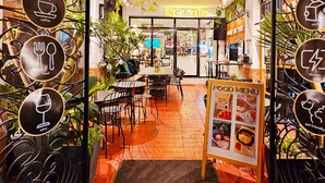 An indoor café with a food menu sign, tables, chairs, and a coffee bar. - Cinema Stay inside Intramuros Manila by IN CAFE (Manila)