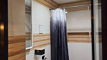 Un baño con inodoro, lavamanos y cortina de ducha.